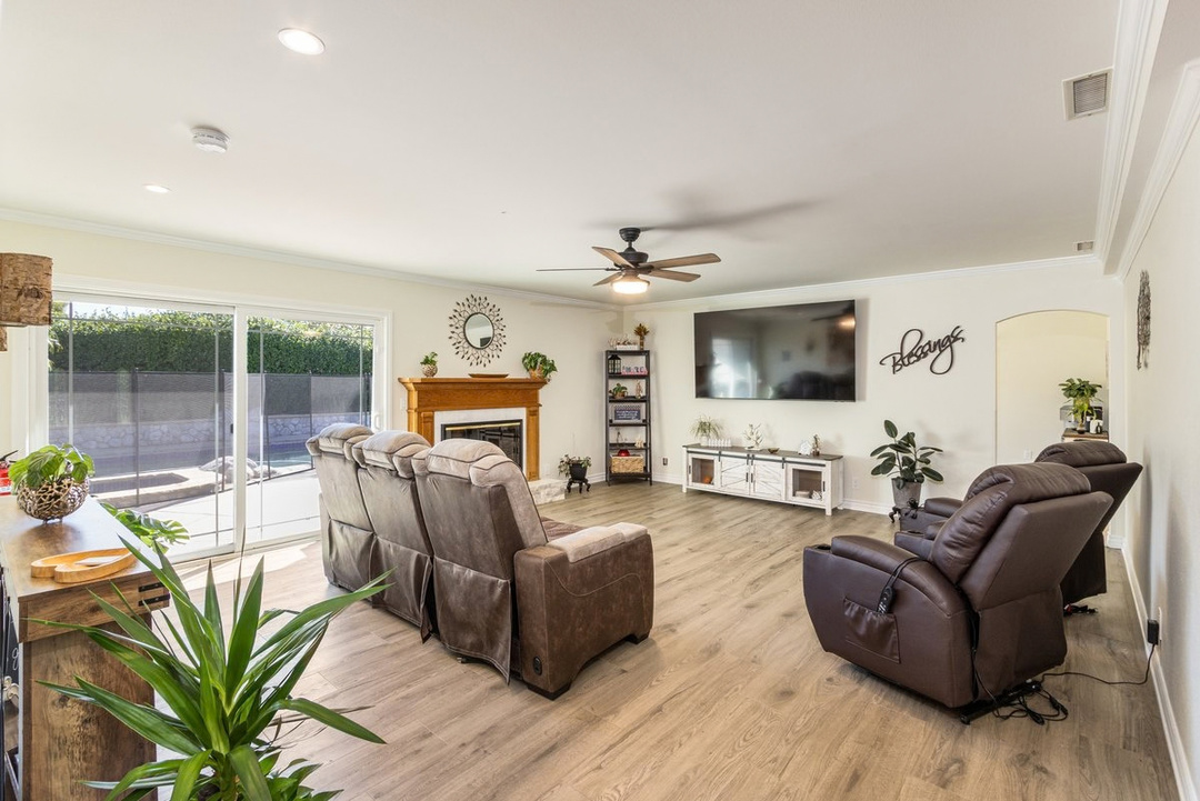 The living room: recliners facing a fireplace and a big-screen TV, with sliding doors to the backyard